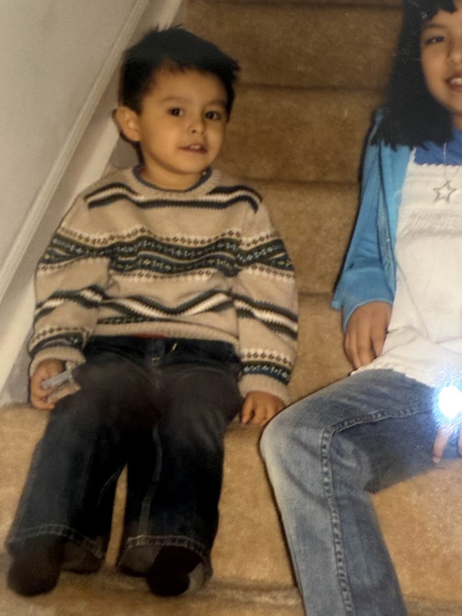 Adrian as a little kid sitting on the stairs